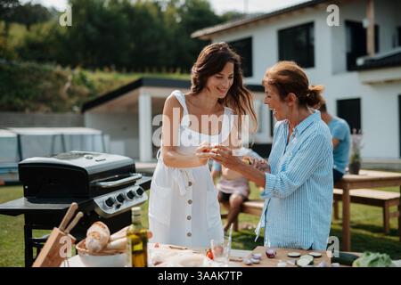 Erwachsene Tochter und Mutter bereiten Essen für einen Familiengrill vor. Stockfoto
