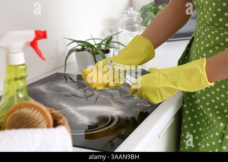 Hausfrau putzt elektrischen Herd mit Essig und Backpulver in der Küche, Nahaufnahme Stockfoto