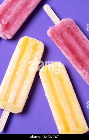 Orange und rosa Eis auf violettem Hintergrund Stockfoto