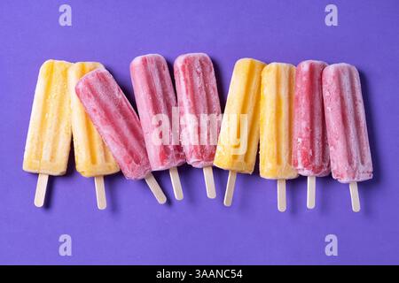 Orange und rosa Eis auf violettem Hintergrund Stockfoto