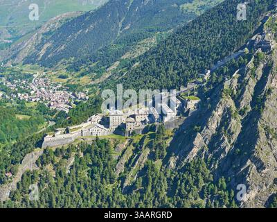 LUFTAUFNAHME. Fenestrelle Fort mit der Stadt Fenestrelle unten im Chisone Valley. Fenestrelle, Metropolstadt Turin, Piemont, italien. Stockfoto