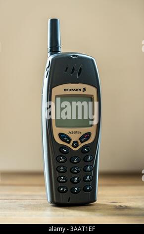 Das Mobiltelefon des alten Ericsson A2618 steht auf einem Holztisch und zeigt sein Retro-Design und seine Technologie aus den frühen 2000er Jahren Stockfoto
