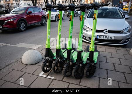 Lemberg, Ukraine - 31. März 2025: Gruppe von grünen Elektrorollern Wings parkten ordentlich auf einem Bürgersteig der Stadt Stockfoto