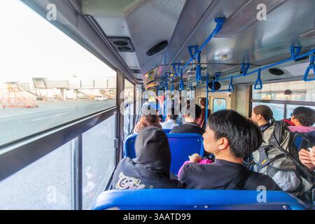 Eine Busladung von Fluggästen fährt zu einem wartenden Flugzeug auf der Rollbahn des Mactan International Airport in Cebu, Philippinen Stockfoto