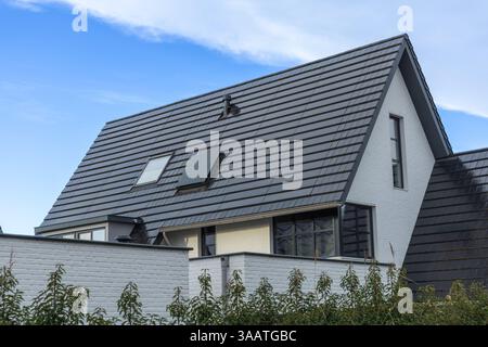 Integrierte Solarpaneele auf dem Dach eines niederländischen Hauses. Photovoltaikpaneele im Dach. Dachziegel von Solar Stockfoto