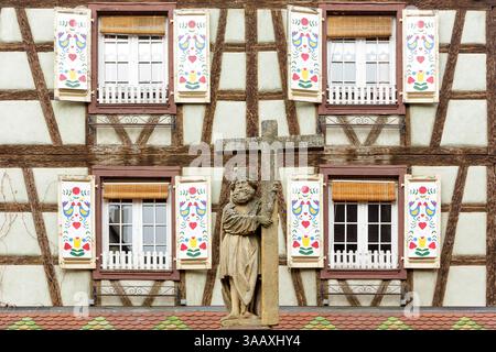 Frankreich, Haut Rhin, Route des Vins d'Elsace, Kaysersberg mit Les Plus Beaux Villages de France (eines der schönsten Dörfer Frankreichs) gekennzeichnet, Detail der Fassade eines traditionellen Fachwerkhauses mit bemalten Fensterläden und Statue von Constantin, die der Bildhauer Hans Bongart 1521 auf dem Constantin-Brunnen in der Rue du General de Gaulle schuf Stockfoto