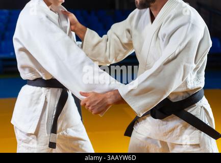 Kampfkunst. Sparende Portners. Sport Mann und Frau in weißem Kimono trainieren Judo-Aufnahmen in der Sporthalle. Foto zuschneiden Stockfoto