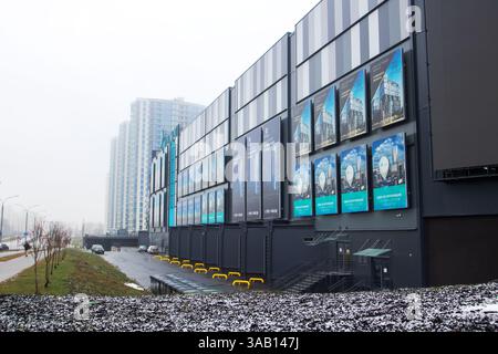 Weißrussland, Minsk - 26, 12, 2024: Ein sehr großes Gebäude in einem städtischen Gebiet mit einer beträchtlichen Anzahl von farbenfrohen Plakaten, die hervorragen Stockfoto