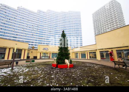 Weißrussland, Minsk - 26, 12, 2024: Ein wunderschön geschmückter Weihnachtsbaum steht majestätisch in der Mitte eines geräumigen Innenhof, direkt im Innenhof Stockfoto