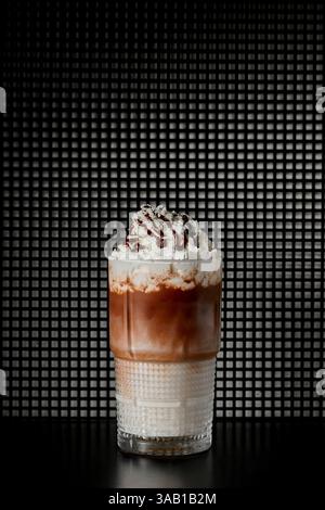 Eiskaffee mit Schlagsahne und Schokolade in einem Glas auf schwarzem Hintergrund Stockfoto