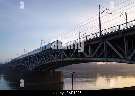 Warschau, Polen. 27. Januar 2025: Zugüberquerung der Srednicowy Railway Bridge am frühen Morgen Stockfoto