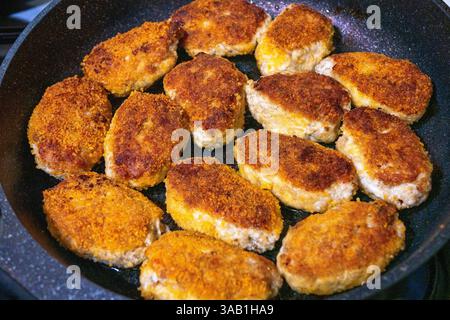 Hausgemachte panierte Schnitzel werden in einer Pfanne frittiert. Nahaufnahme. Stockfoto