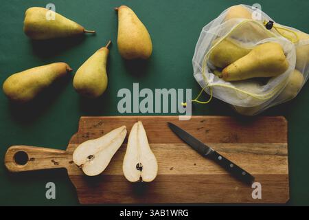 Draufsicht auf Birnen in wiederverwendbaren Beutel und auf Schneidebrett Stockfoto