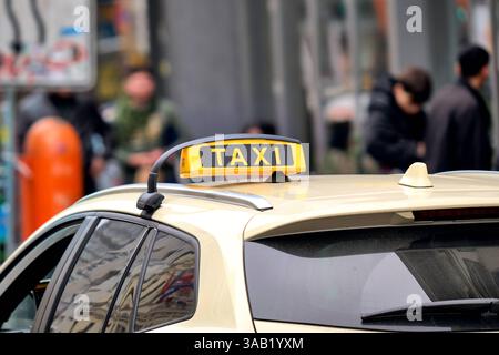 Berlin, Deutschland - 27. März 2025: Taxi in Berlin, klassisches gelbes Dachschild auf einem Taxi, auf der Straße im Berliner Stadtverkehr *** Taxi in Berlin, klassisches Gelbes Dachzeichen auf einem Taxi, unterwegs im Berliner Stadtverkehr Stockfoto
