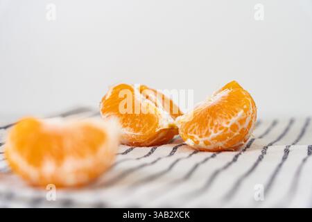 Muster ganzer Mandarinen oder Mandarinen-Orangen-Früchte und geschälter Segmente, isoliert auf weißem Hintergrund. Stockfoto