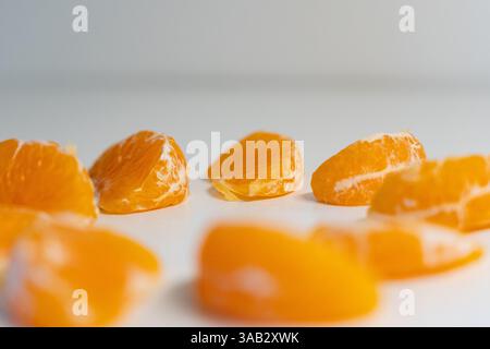 Muster ganzer Mandarinen oder Mandarinen-Orangen-Früchte und geschälter Segmente, isoliert auf weißem Hintergrund. Stockfoto