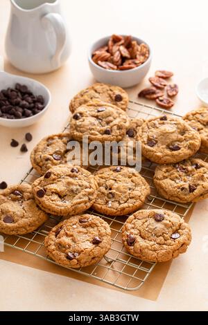 Schokoladen-Chip-Cookies mit Pekannüssen, frisch gebackene Kekse auf einem Kühlregal serviert mit Milch Stockfoto
