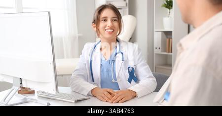 Ärztin mit Prostatakarzinom-Sensibilisierungsband und Patient in der Klinik Stockfoto