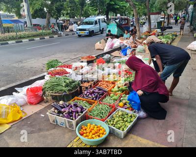 Indonesische Straßenverkäufer verkaufen frisches Gemüse auf dem Boden eines Bürgersteigs in Senen, Jakarta. Stockfoto