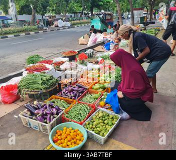 Indonesische Straßenverkäufer verkaufen frisches Gemüse auf dem Boden eines Bürgersteigs in Senen, Jakarta. Stockfoto