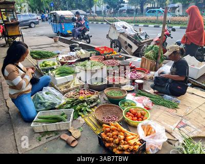 Indonesische Straßenverkäufer verkaufen frisches Gemüse auf dem Boden eines Bürgersteigs in Senen, Jakarta. Stockfoto