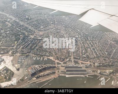Aus der Vogelperspektive von Amsterdam, Niederlande, mit Blick auf die Kanäle der Stadt, die historische Architektur und den Amsterdamer Hauptbahnhof, Stockfoto