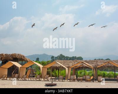 Strandzelte und Sonnenliegen an der Mündung des Rio Don Diego, Sierra Nevada de Santa Marta, Kolumbien Stockfoto