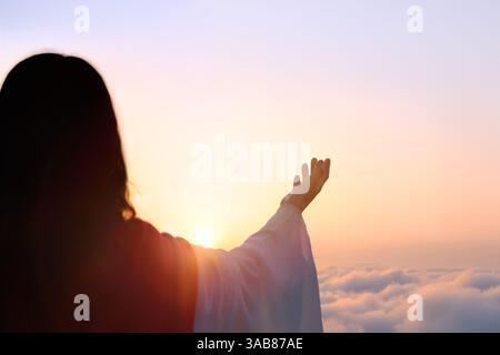 Jesus betet zu Gott mit den Armen, die zum hellen Himmel gerichtet sind, Jesus Christus auferstanden aus dem Kreuz Tod, Ostern Hintergrund Stockfoto