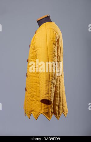 Gelbe Gepolsterte Gambeson-Jacke. Gesteppte Unterpanzerung im Mittelalter mit Lederriemen. Stockfoto