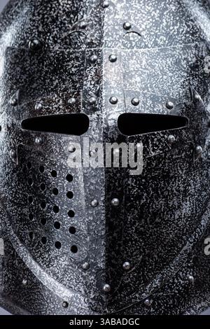 Geschlossener mittelalterlicher Ritterhelm mit kleinen Perforationen. Dieses Bild zeigt einen geschlossenen mittelalterlichen Ritterhelm, wahrscheinlich aus Stahl, mit einer spitzen Spitze Stockfoto