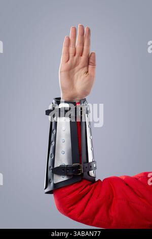 Nahaufnahme der silbernen Schienenkarmbänder auf roter gepolsterter Rüstung. Dieses Bild zeigt eine Nahaufnahme von silbernen Metallschienen, die über einem rot gepolsterten Kleidungsstück getragen werden. Stockfoto
