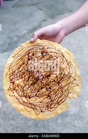 Kabkab, eine traditionelle philippinische Süßigkeit aus dünn gepresstem Maniok, gebraten bis knusprig und garniert mit einem Schuss Zuckersirup Stockfoto