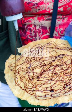 Kabkab, eine traditionelle philippinische Süßigkeit aus dünn gepresstem Maniok, gebraten bis knusprig und garniert mit einem Schuss Zuckersirup Stockfoto