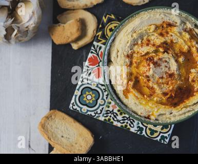 Schöne Schüssel Hummus, traditionelles vegetarisches Gericht aus dem Nahen Osten auf Basis von Kichererbsen, gewürzt mit Olivenöl und Paprika Stockfoto