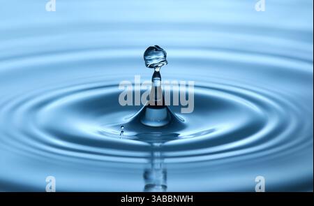 Wassertropfen mit wellenförmiger Form im Detail, die Wellen in blauem, gestochen scharfem Studio erzeugt Stockfoto