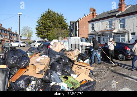 Herrick Road, Birmingham, 2. April 2025: Als Birmingham aufgrund des anhaltenden Streiks zur Müllabfuhr einen großen Vorfall erklärte, kamen Mitglieder der Gemeinde in Kraft, um den mit Fliegenkippen versehenen Müll von einer Straßenecke im Alum Rock Gebiet der Stadt zu beseitigen, nachdem er am Dienstag Abend in Brand gesetzt wurde. Fünfundzwanzig Freiwillige brachten den Abfall zu einer Müllsammelstelle in 100 Metern Entfernung. An der Müllsammelstelle häuften sich Warteschlangen an, als die Leute ihre eigenen Mülltonnen und Müllsäcke mitbrachten, um sie zu entsorgen, nachdem sie wochenlang keine Sammlungen mehr gesammelt hatten. Community-Mitglied Shaukat Mahmood, 53 aus Alum Rock Stockfoto