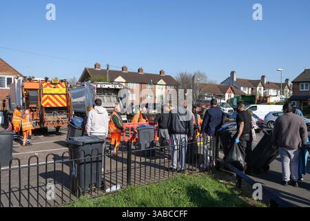 Herrick Road, Birmingham, 2. April 2025: Als Birmingham aufgrund des anhaltenden Streiks zur Müllabfuhr einen großen Vorfall erklärte, kamen Mitglieder der Gemeinde in Kraft, um den mit Fliegenkippen versehenen Müll von einer Straßenecke im Alum Rock Gebiet der Stadt zu beseitigen, nachdem er am Dienstag Abend in Brand gesetzt wurde. Fünfundzwanzig Freiwillige brachten den Abfall zu einer Müllsammelstelle in 100 Metern Entfernung. An der Müllsammelstelle häuften sich Warteschlangen an, als die Leute ihre eigenen Mülltonnen und Müllsäcke mitbrachten, um sie zu entsorgen, nachdem sie wochenlang keine Sammlungen mehr gesammelt hatten. Community-Mitglied Shaukat Mahmood, 53 aus Alum Rock Stockfoto