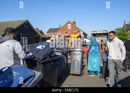 Herrick Road, Birmingham, 2. April 2025: Als Birmingham aufgrund des anhaltenden Streiks zur Müllabfuhr einen großen Vorfall erklärte, kamen Mitglieder der Gemeinde in Kraft, um den mit Fliegenkippen versehenen Müll von einer Straßenecke im Alum Rock Gebiet der Stadt zu beseitigen, nachdem er am Dienstag Abend in Brand gesetzt wurde. Fünfundzwanzig Freiwillige brachten den Abfall zu einer Müllsammelstelle in 100 Metern Entfernung. An der Müllsammelstelle häuften sich Warteschlangen an, als die Leute ihre eigenen Mülltonnen und Müllsäcke mitbrachten, um sie zu entsorgen, nachdem sie wochenlang keine Sammlungen mehr gesammelt hatten. Community-Mitglied Shaukat Mahmood, 53 aus Alum Rock Stockfoto