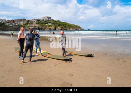 Eine Gruppe männlicher Surfer, die sich am Towan Beach in Newquay in Cornwall unterhalten. Stockfoto