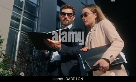 Zwei kaukasische Geschäftsleute Kollegen in der Stadt Downtown reden zusammen arbeiten über Papiere Dokumente Mann Geschäftsmann Mann männlich mit Stockfoto