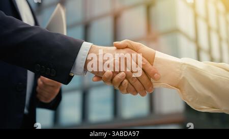 B2B-Konzept Arbeitsbeziehung Partnerschaft Handshake zwei Geschäftsleute in der Stadt Frau Mann Treffen Händeschütteln Einheit Zusammenarbeit Abschluss Job Recruit Stockfoto