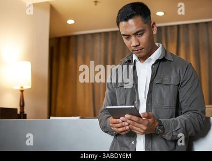 Ein zuversichtlicher Rezeptionist hilft Gästen in der modernen Hotellobby Stockfoto