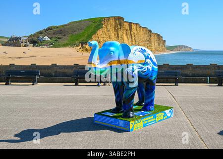 West Bay, Dorset, Großbritannien. April 2025. Wetter in Großbritannien. Eine farbenfroh bemalte Elefantenskulptur, die Teil des Kunstwegs Stampede by the Sea in West Bay in Dorset ist, an einem Tag mit heißem Frühlingssonne und klarem blauem Himmel . Bildnachweis: Graham Hunt/Alamy Live News Stockfoto