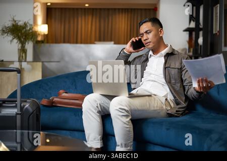 Geschäftsleute arbeiten während der Reise in der Hotellobby Stockfoto
