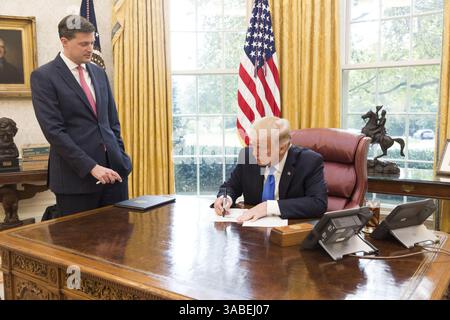 25. Oktober 2017 - Washington, District of Columbia, Vereinigte Staaten von Amerika - Präsident Donald J. Trump, wird von Rob Porter, Staff Secretary des Weißen Hauses, Mittwoch, 25. Oktober 2017, im Oval Office des Weißen Hauses in Washington, D.C. begleitet, während er ein PräsidentenMemorandum unterzeichnet, das ein neues Pilotprogramm zur Drohnenintegration schafft, das die Integration von Drohnen in das nationale Luftraumsystem beschleunigen wird...People: (Bild: © SMG via ZUMA Wire) Stockfoto