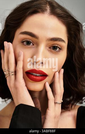 Eine junge Frau zeigt ihre Schönheit mit leuchtend roten Lippen, wunderschön eingerahmt von Zahnspangen. Stockfoto