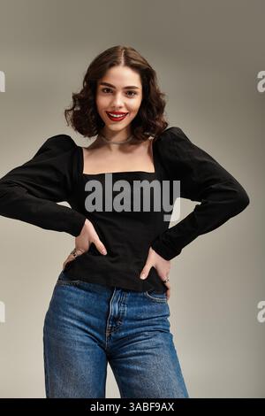 Eine junge Frau mit helläugigen Augen zeigt ihre Schönheit mit roten Lippen und Zahnspangen, während sie anmutig posiert. Stockfoto