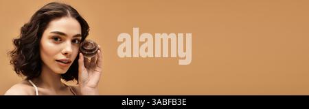 Hübsche junge Frau zeigt ihre Schönheitspflege-Routine und hebt glatte Haut hervor, Banner Stockfoto