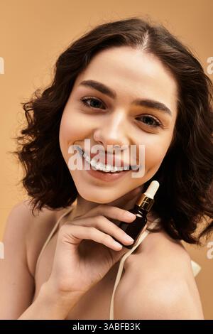 Eine junge Frau mit Zahnspangen zeigt selbstbewusst ihre Hautpflegeroutine in einem Studio. Stockfoto