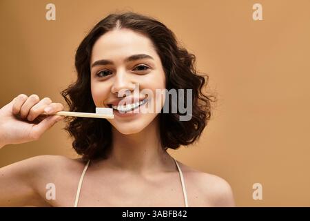 Eine junge Frau mit Zahnspangen genießt ihre Zahnarztpraxis, während sie in einem Studio hell lächelt. Stockfoto